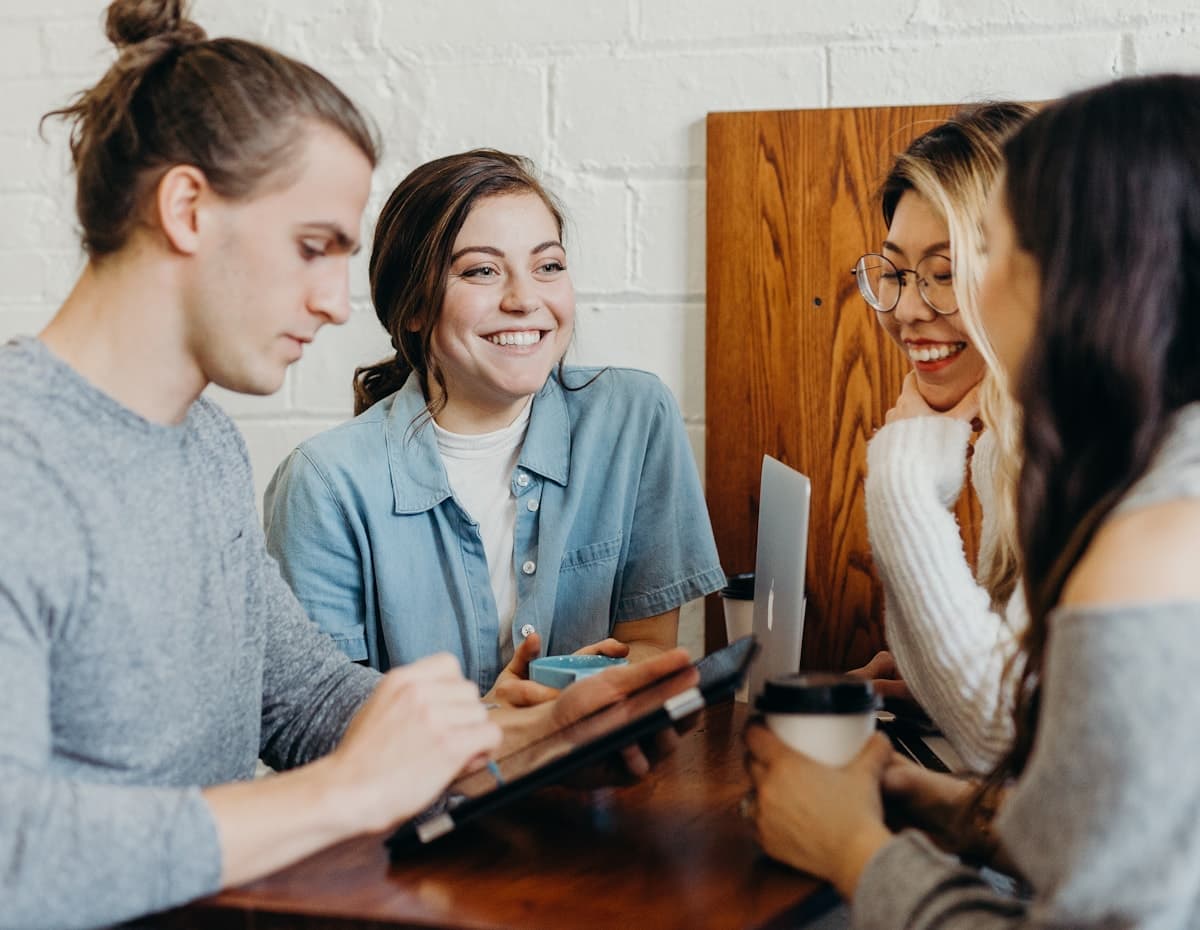 A group in conversation around a table, listening and building on each other's thinking